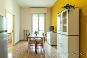 a kitchen with a table and chairs and a refrigerator at Gala158UNO in Bologna