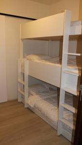 ニーウポールトにあるGelijkvloers vakantie-appartement met groot zonnig terrasの二段ベッド2組が備わる客室です。 +4枚の写真