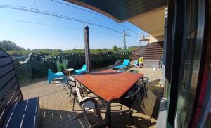 ニーウポールトにあるGelijkvloers vakantie-appartement met groot zonnig terrasのパティオにある木製のテーブルと椅子
