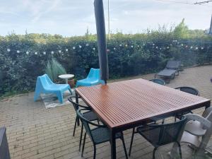 ニーウポールトにあるGelijkvloers vakantie-appartement met groot zonnig terrasのパティオにある木製のテーブルと椅子