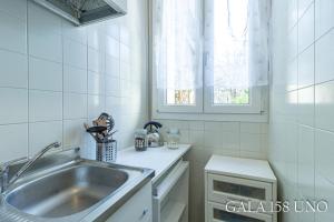 una cucina bianca piastrellata con lavandino e finestra di Gala158UNO Fair With Parking a Bologna Altre 62 foto