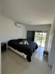 ein Schlafzimmer mit einem Bett mit zwei ausgestopften Tieren darauf in der Unterkunft Casa com piscina in Capão da Canoa