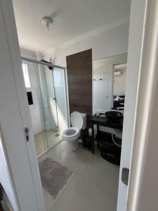 a bathroom with a toilet and a shower and a sink at Casa com piscina in Capão da Canoa