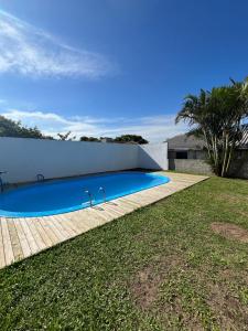 a swimming pool in the backyard of a house at Casa com piscina in Capão da Canoa