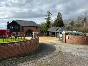 a house with a brick wall next to a fence at NEW King Bed Romantic Cabin - Must See Landscapes in Salisbury