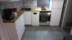 a kitchen with white cabinets and a white refrigerator at CHALET B NATURISTe MAEVA in Le Porge +12 photos