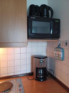 a microwave sitting on a shelf above a coffee maker at Bayern Ferienland Sonnenwald in Schöfweg