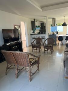 uma sala de estar com várias cadeiras e uma cozinha em Casa com piscina em Capão da Canoa