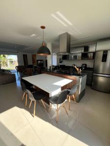 uma cozinha com uma mesa e cadeiras numa cozinha em Casa com piscina em Capão da Canoa