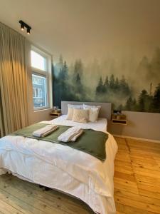 Schlafzimmer mit einem Bett mit Wandgemälde in der Unterkunft Maison d’Arnaud in Gent