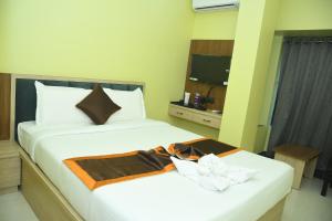 a hotel room with two beds and a television at Hotel Royal Orbit in Contai
