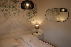 a bedroom with a bed with a lamp and a mirror at Auszeit am See in Plau am See