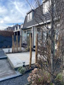 een huis met een veranda en een houten terras bij Holiday in Spakenburg Ootje in Spakenburg