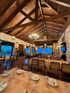 a dining room with wooden ceilings and tables and chairs at Guesthouse Kastania Korakis in Kastania