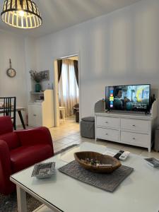een woonkamer met een tv en een tafel bij Gianna’s apartment central Aigio Cozy and Shining in Aigio