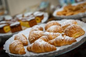 a bunch of pastries on a plate on a table at Hotel Iris in Genoa