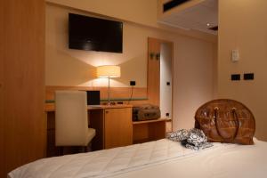 a bedroom with a bed with a desk and a television at Hotel Iris in Genoa