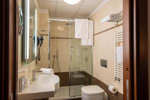 a bathroom with a shower and a toilet and a sink at Hotel Iris in Genoa