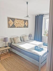 a bed in a room with blue curtains and a bed at Mozaika Art Apartment PL LT EN in Suwałki