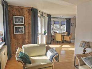 a living room with a couch and a dining room at Mozaika Art Apartment PL LT EN in Suwałki