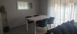 a white table and chairs in a room with a window at Apartments near old town with private parking in Kaunas