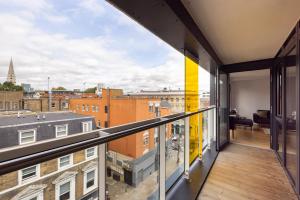 an apartment balcony with a view of a city at The Sloane Apartment in London