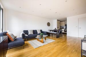 uma sala de estar com um sofá e uma mesa em The Sloane Apartment em Londres