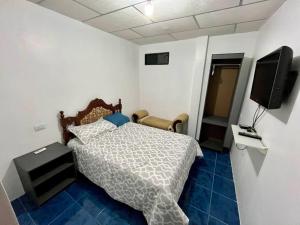 a bedroom with a bed and a flat screen tv at Hospedaje El Descanso CERCA CONSULADO AMERICANO GUAYQUIL in Guayaquil