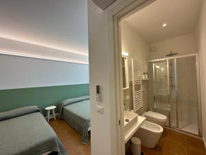 een slaapkamer met een bed en een badkamer met een douche bij Green House Camerano in Camerano +18 foto's