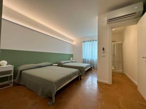 een slaapkamer met twee bedden en een groene muur bij Green House Camerano in Camerano