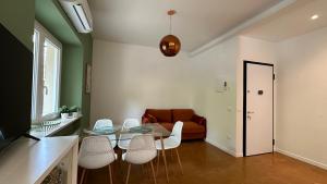 een woonkamer met een glazen tafel en witte stoelen bij Green House Camerano in Camerano