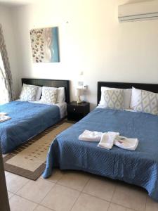 a bedroom with two beds with towels on them at Villa Jazmin in Marioú +22 photos