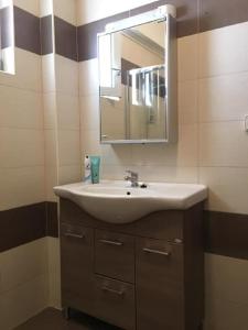 a bathroom with a sink and a mirror at Villa Jazmin in Marioú