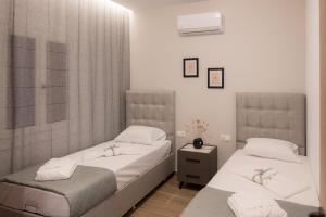 2 camas en una habitación con paredes blancas en Swell Oinousses Apartments, en Oinoússai