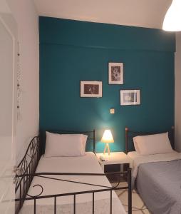 1 dormitorio con 2 camas y pared azul en margarita home, en Kalamata