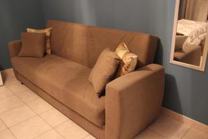 um sofá castanho com almofadas num quarto em B&B Sud e Magia em Castelmezzano