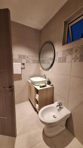 a bathroom with a sink and a toilet and a mirror at Residence Capri in Mont Choisy