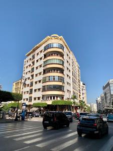 a large building with cars parked in front of it at Elegant and Panoramic 3-Bedroom in Central Tangier in Tangier