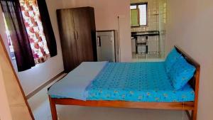 ein kleines Schlafzimmer mit einem blauen Bett in einem Zimmer in der Unterkunft RN GUEST HOUSE ARAMBOL GOA in Arambol