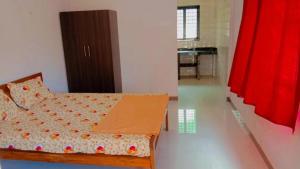 ein Schlafzimmer mit einem Bett mit einem roten Vorhang in der Unterkunft RN GUEST HOUSE ARAMBOL GOA in Arambol