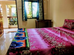 Schlafzimmer mit einem rosa Bett und einem Spiegel in der Unterkunft RN GUEST HOUSE ARAMBOL GOA in Arambol