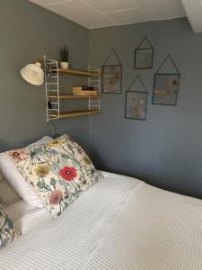 Dormitorio con cama con almohada de flores en la pared en Trennegården B&B, en Mjöhult