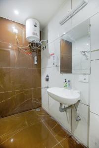 een badkamer met een wastafel en een spiegel bij Hotel Square Philip in Banūr