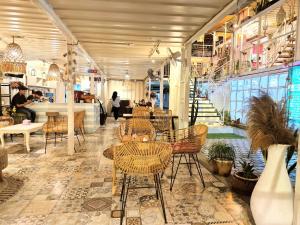 un ristorante con sedie e tavoli in una stanza di Karcof Container Hostel a Senggigi