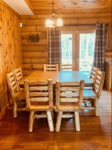 una sala da pranzo con tavolo e sedie in legno di The Forest Edge Cabin a Sigel