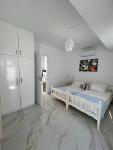 a white bedroom with a bed and white cabinets at Maria's Apartments in Pigi