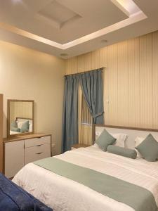 a bedroom with a large bed and a mirror at Rose Park Riyadh in Riyadh