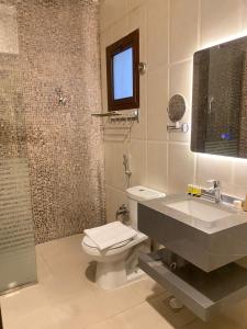uma casa de banho com um WC, um lavatório e um chuveiro em Rose Park Riyadh em Riyadh