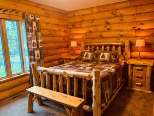 una camera con un letto in una baita di tronchi di The Forest Edge Cabin a Sigel