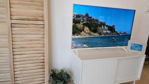 uma televisão numa parede num quarto em HoliVibes - sea view - Bulgaria em Sveti Vlas